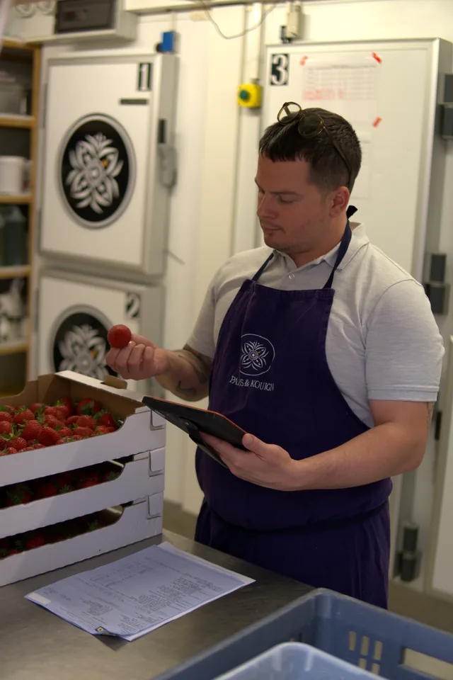 Professionnel contrôlant des fraises à leur réception avec une tablette Traceo.