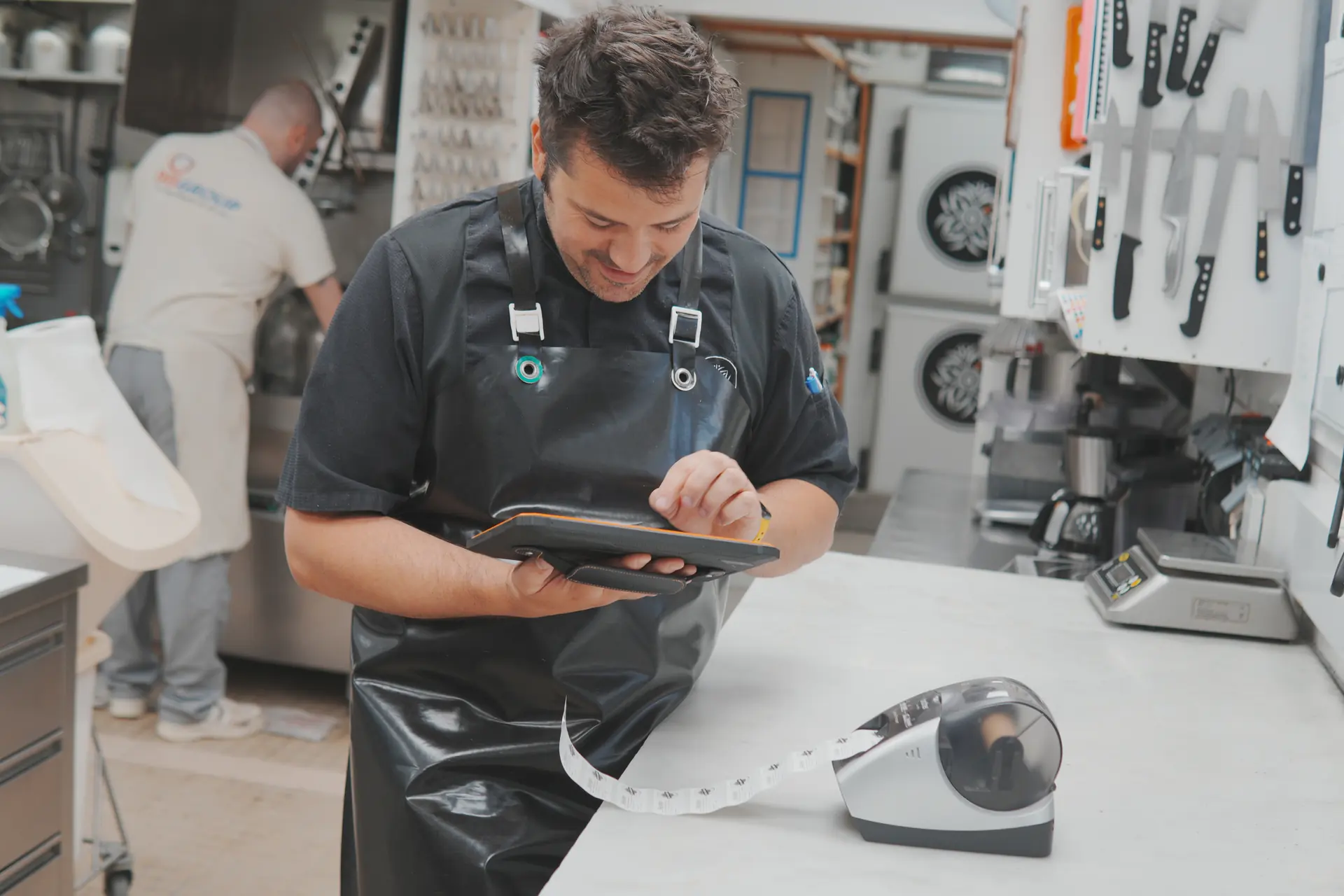 Cuisinier utilisant l’appli de traçabilité Traceo sur tablette avec une imprimante d’étiquettes