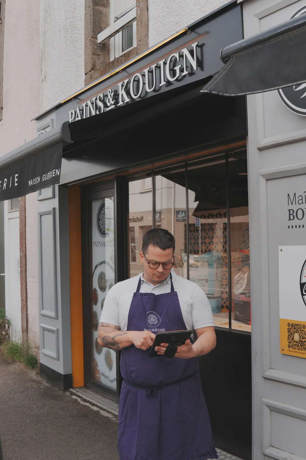 Profesionist ținând o tabletă Traceo în fața brutăriei Pains et Kouign.